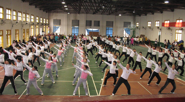 女教工们在分批表演广播体操。