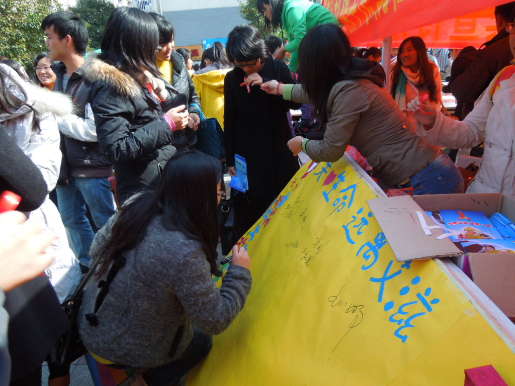 志愿者在向同学们分发红丝带