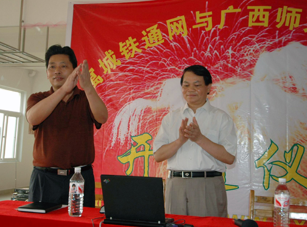 我校副校长蓝常周（右）与中国铁通桂林分公司罗卫洲副总经理共同点击电脑，实现公寓城网络与我校校园网互连。