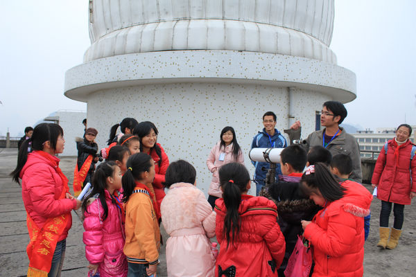 青年志愿者们带领小学生参观天文台，了解天文知识