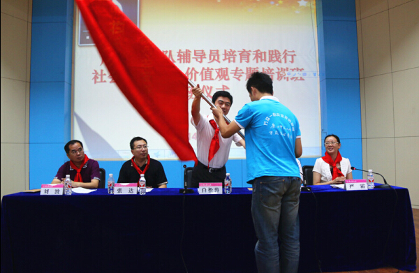 共青团广西区委书记白松涛给“万众爱心学校”服务团授旗