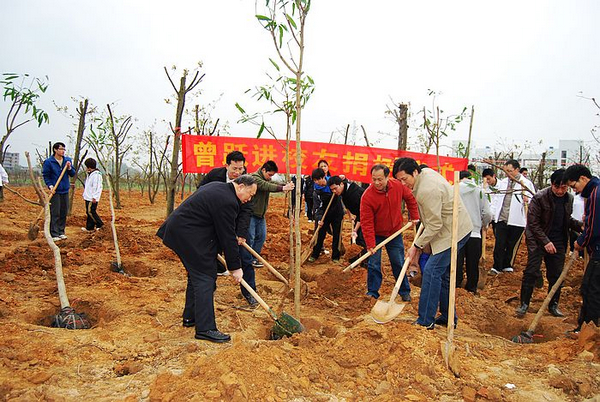 刘健斌副校长（左一）和曾跃进校友(右三）共同为树木培土