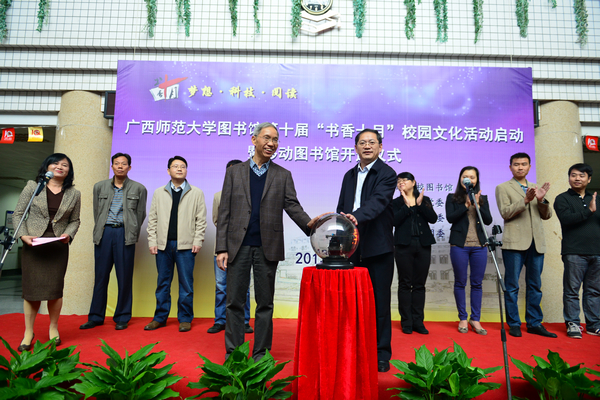 2013年10月18日，杨善朝（图左）启动学校移动图书馆项目