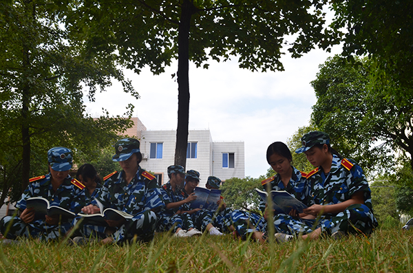 训练间隙，同学们津津有味地阅读我校自行编写的大学生国防教育教材