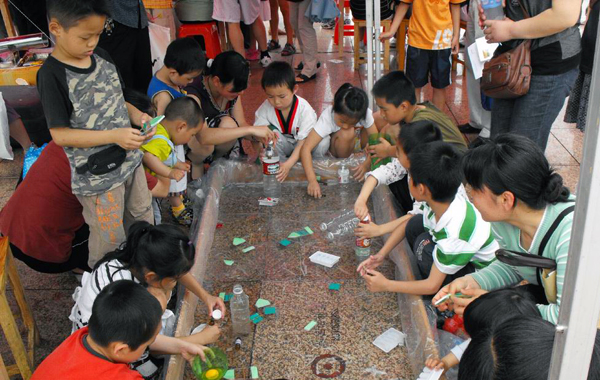 小学生们在我校的展品前动手实验。