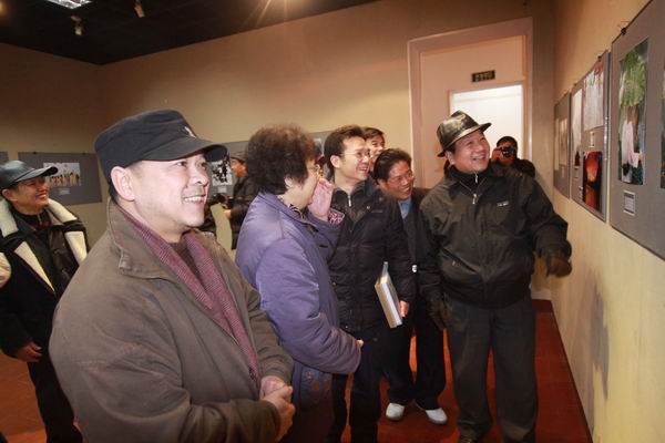 原桂林市副市长林观华（右一）、我校副校长白晓军（左一）等领导兴致勃勃地观看展出的摄影作品