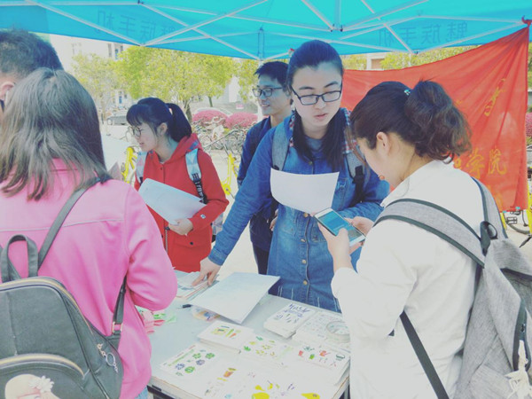 同学们在活动现场关注进行答题抽奖活动.jpg