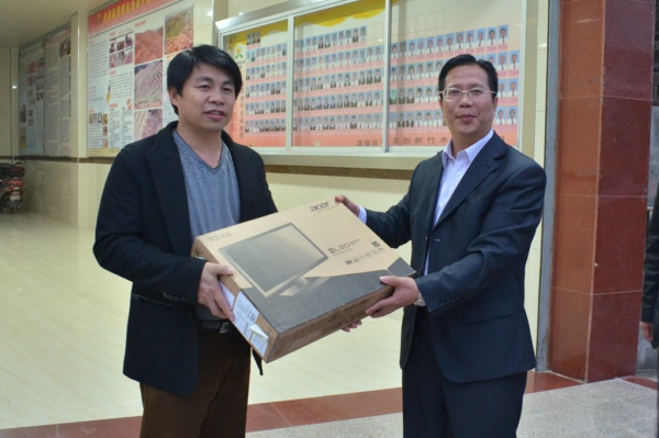 副校长覃卫国代表学校向我校驻村书记点赠送电脑等办公用品