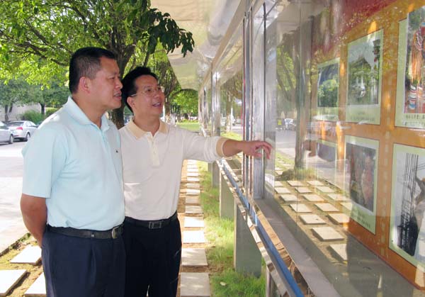校党委副书记王源平（左）参观了摄影展。