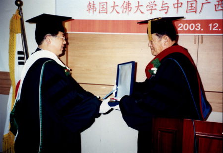 图为黄介山教授（左）在接受名誉博士学位授予。