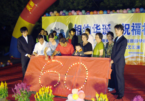 ６位六十岁的老人与学生共同点燃祝福祖国的蜡烛。