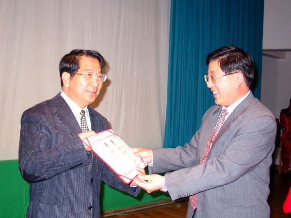 我校党委书记黄介山（右）给吕聪敏教授颁发聘书。