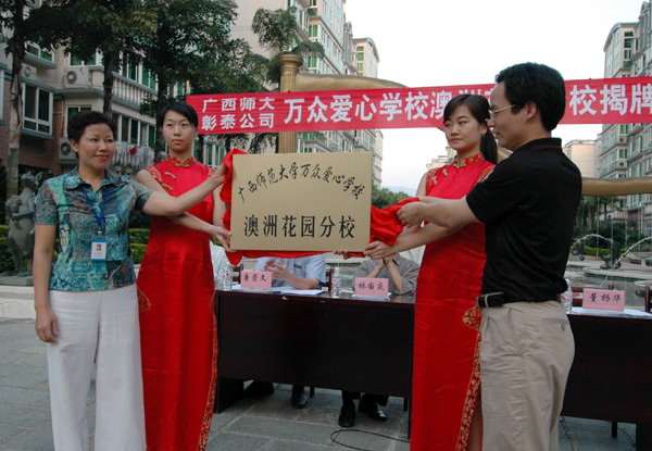 校团委负责人（右）与桂林彰泰物业公司负责人共同为澳洲花园“万众爱心学校”分校揭牌。