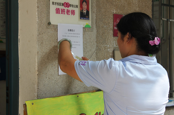 舍管为新生粘贴温馨提示（大学生通讯社 蒋晨曦 摄）
