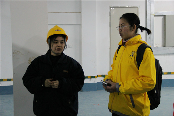 刘露同学听技术员讲解自己的工作，并进行采访