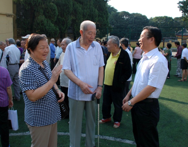 覃卫国（右）与离休干部亲切交谈