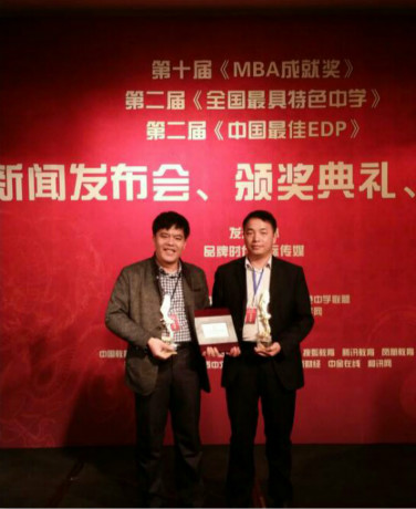MBA杰出教授陆奇岸（左）和MBA毕业生罗锦文（右）在领奖台上合影.