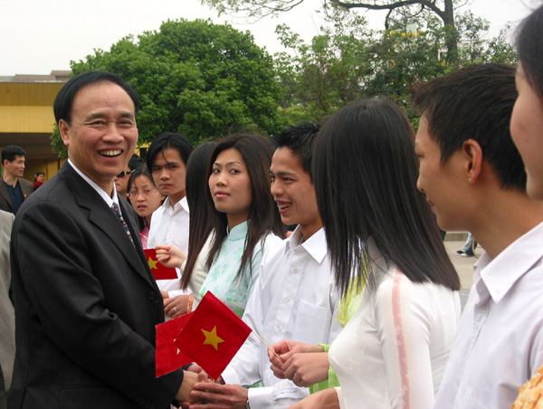 陈庭欢亲切地与夹道迎接他的越南留学生们握手会面。