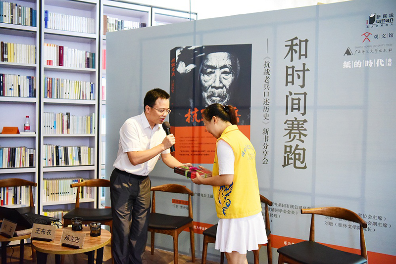 广西师范大学出版社副总编辑汤文辉给老兵捐赠《抗战老兵口述历史》（老兵志愿者代领)（李显杨摄）.JPG