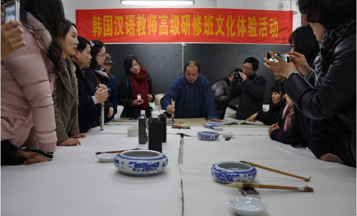 美术学院黎东明教授在活动现场向韩国客人展示书法书写技艺