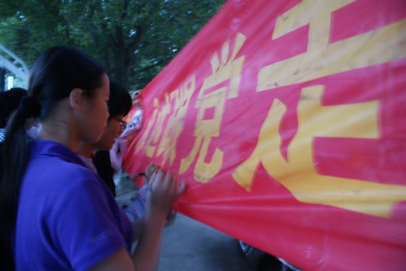青年骨干们相继在“做坚定的马克思主义者，永远跟党走”的横幅上签名