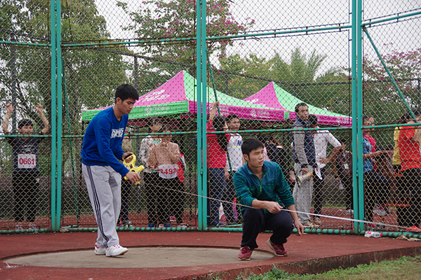 工作人员测量女子铁饼距离（大学生通讯社 陈荟霖 摄）