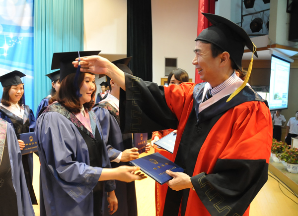 留学生毕业典礼上，校长梁宏为留学生颁发学位证书，并拨正流苏（大学生记者团 邓永霞 摄）
