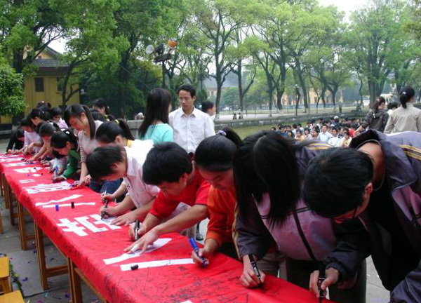 同学们在“践行‘八荣八耻’、争做诚信学子”的横幅上郑重签名。