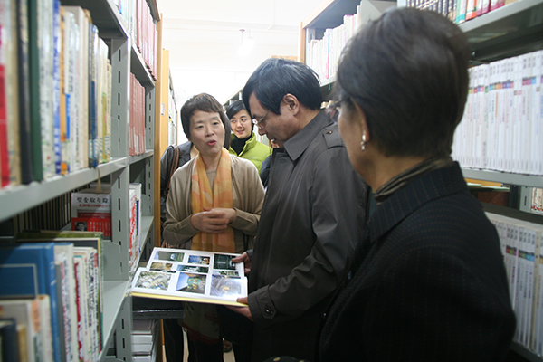 李传起副校长与日本友人一起查看日文赠书,对日本科学协会的捐赠表示感谢(右二)