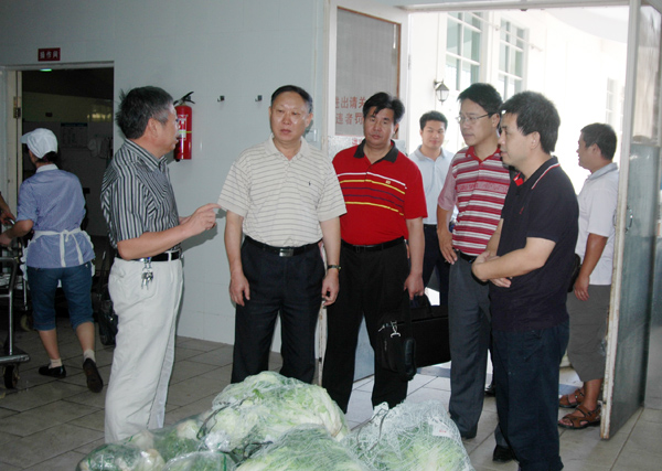 刘健斌副校长（左二）一行实地检查了食堂的食品供给处。