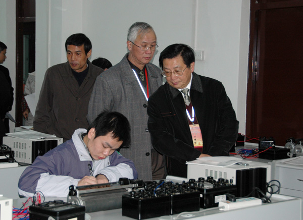 专家组组长万辅彬教授（右一）在对学生进行物理实验技能测试。