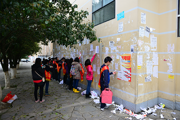 志愿者们清理校园小广告(韦一琦 摄)