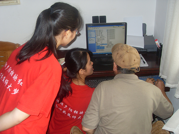志愿者教李老师使用电脑