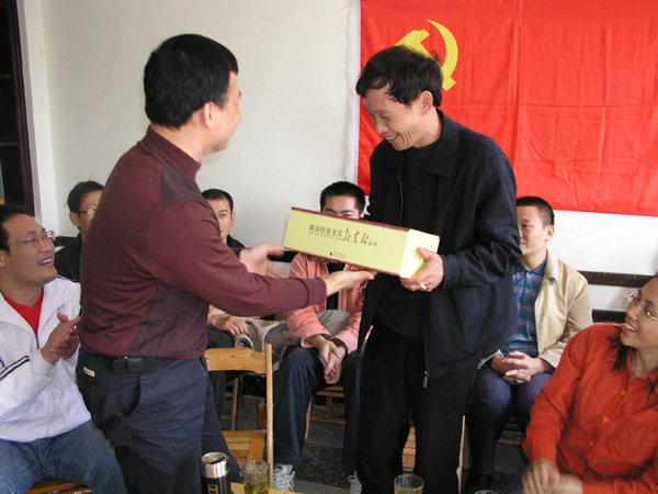成教院党员们向红岩村赠送有关建设社会主义新农村的书籍。