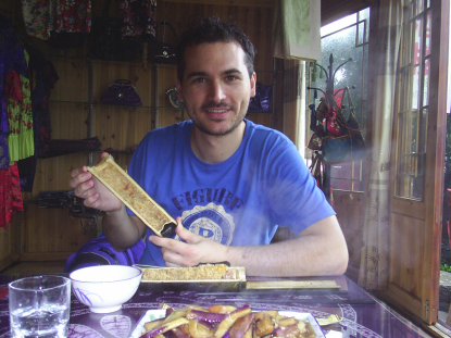 西班牙留学生卡卢斯在品尝农家竹筒饭