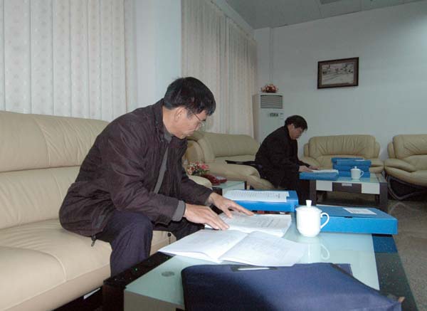 考核组成员仔细查阅创建工作档案资料