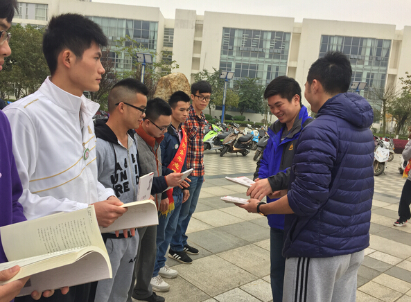 老师为志愿者代表颁发《雷锋精神读本》书籍