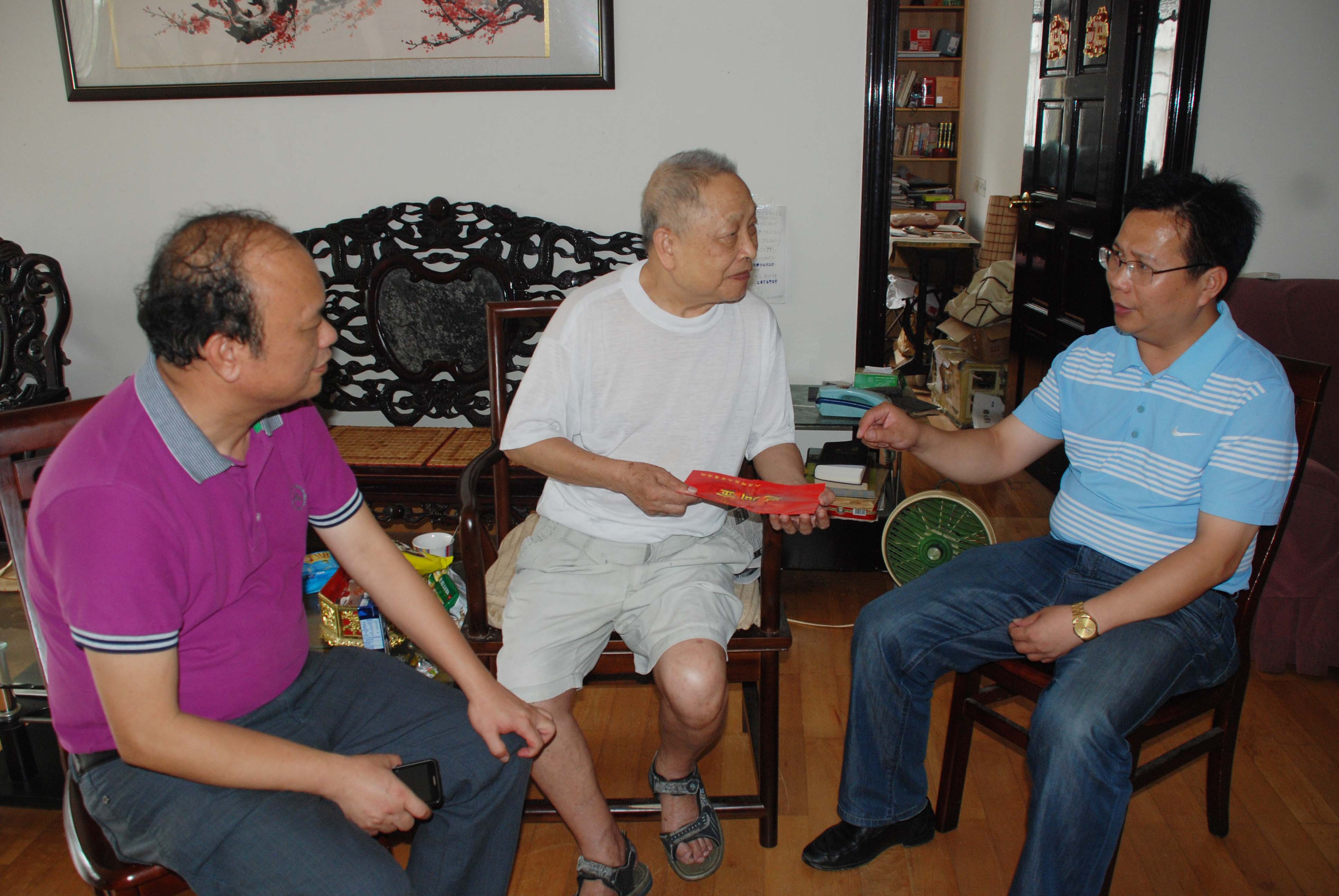 覃卫国副校长(图右)在老同志家中亲切交谈