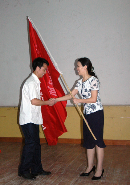校党委林娜副书记为大学生志愿者团队授旗。