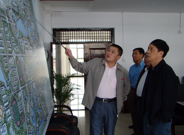 校党委王源平副书记（左一）向来访的客人介绍我校新校区的建设规划。