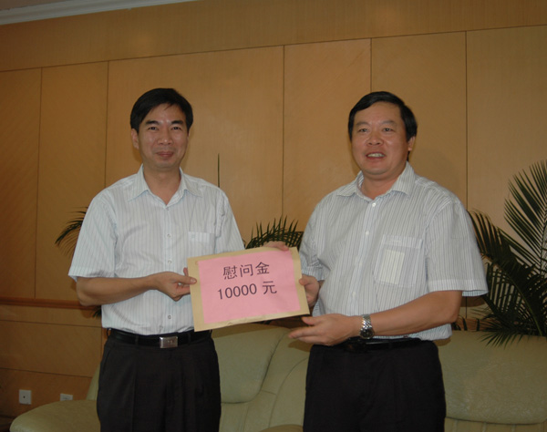 张秀隆市长（右一）将慰问金送到梁宏校长（左一）手中