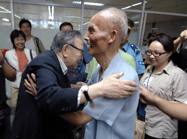 梁羽生先生（左）与钟文典教授热情拥抱。