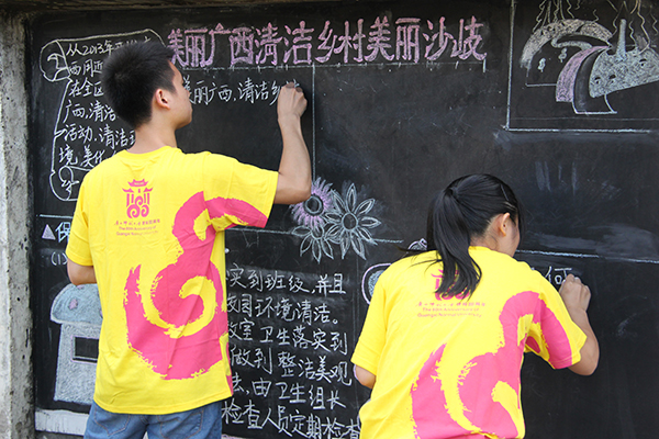 实践队员绘制“美丽广西·清洁乡村”宣传板报