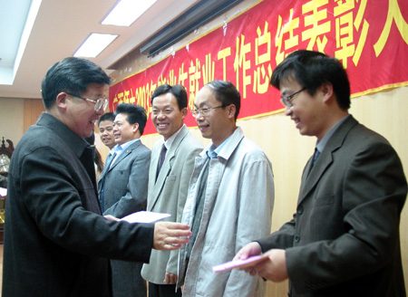图为校党委书记黄介山（左一）在给获得先进个人的同志颁发奖金。