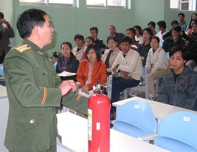 图为黄华山参谋正在给同学们演示如何使用灭火器。