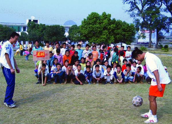 体育学院05研党支部党员给中心校学生们进行足球技能培训。