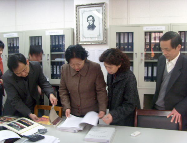 校党委王枬书记（左二）在音乐学院评建办检查评建材料。