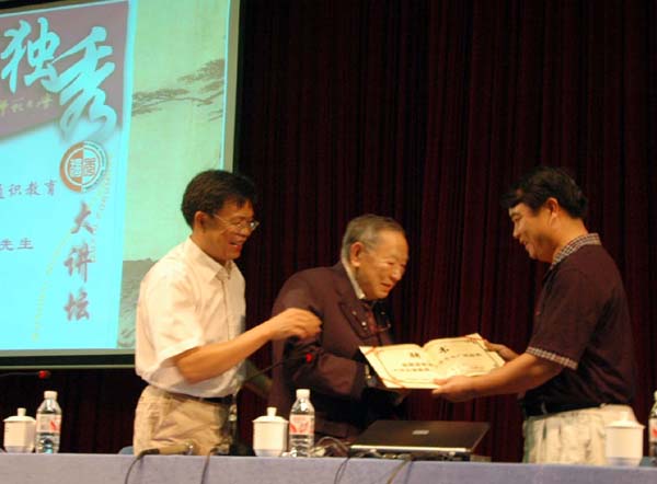 图为校党委书记陈大克（右一）给梁羽生先生（中）颁发名誉教授聘书